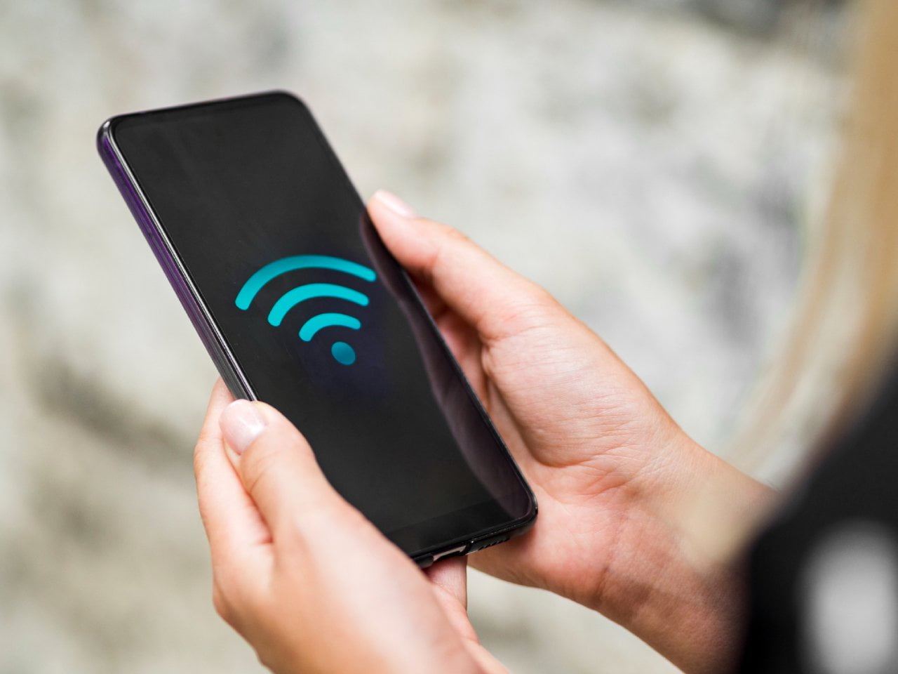 Segurando Smartphone com Simbolo de Wifi na Tela